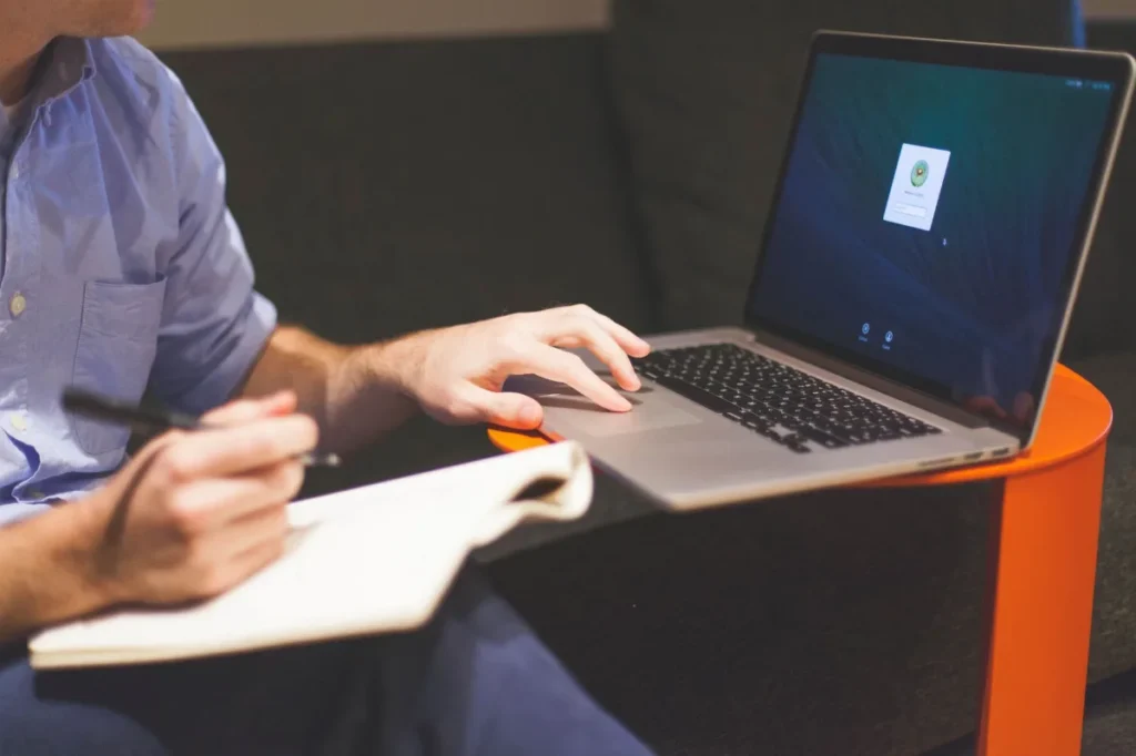Meja kerja penulis konten dengan laptop, buku catatan, dan kopi